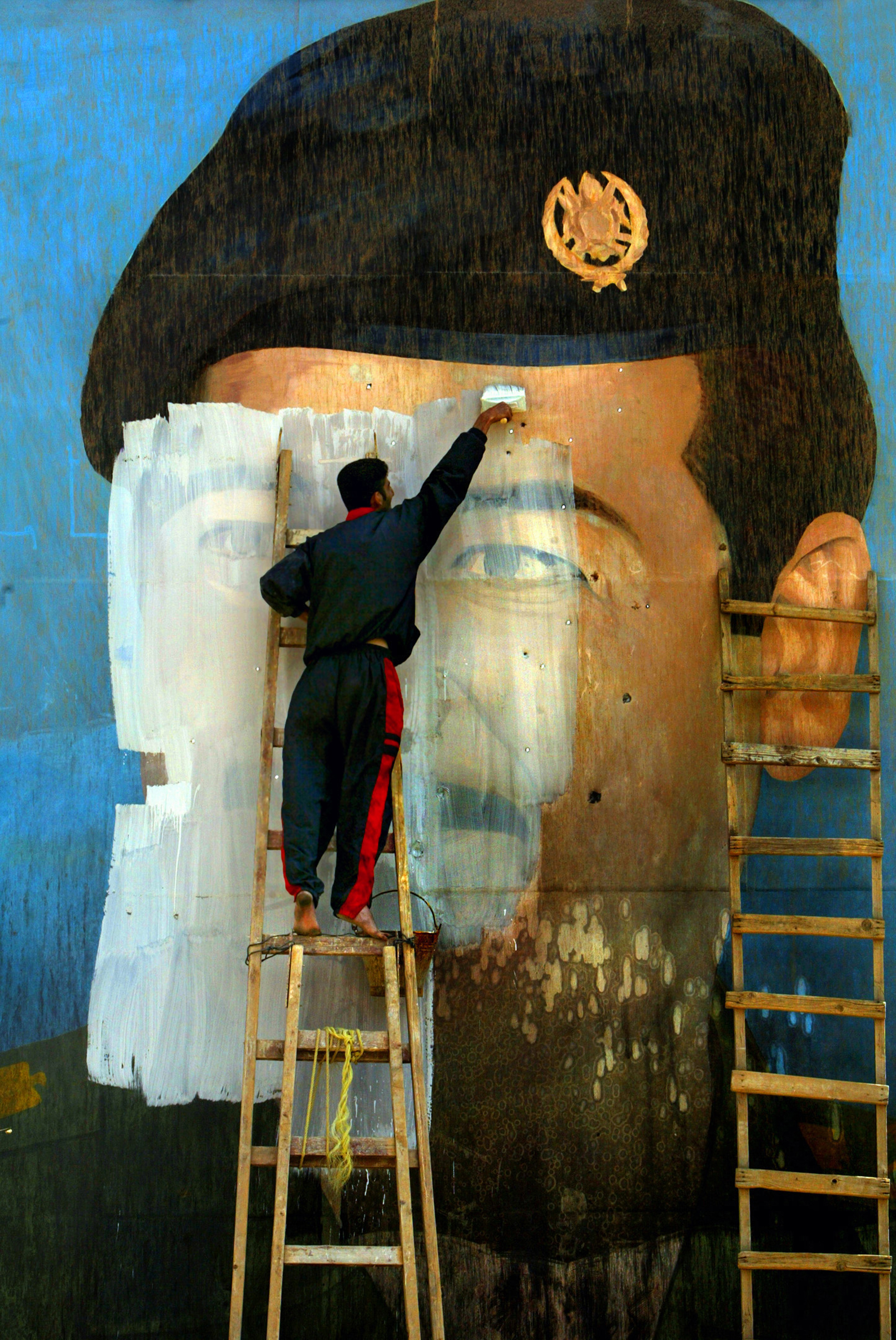 Carolyn Cole, Une photo de Saddam Hussein, criblée d’impacts de balles et recouverte de peinture par Salem Yuel. Bagdad, Irak, avril 2003 © Carolyn Cole / Los Angeles Times
