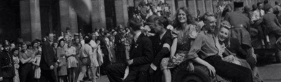 Des jeunes gens descendent à la suite du général de Gaulle dans la rue de Rivoli pavoisée aux couleurs des Alliés. Paris, 26 août 1944.