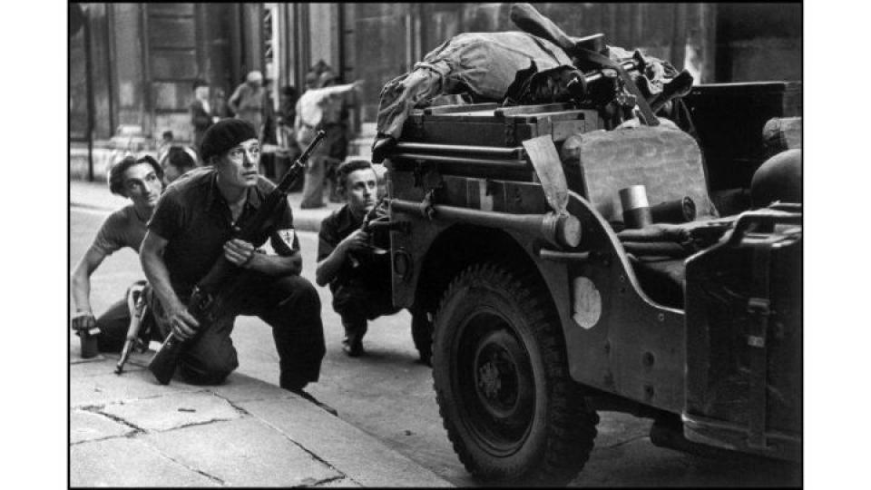 Membres de la résistance accroupis derrière un camion pendant la Libération, Paris, France, 25 août 1944 Crédit : Robert Capa/ International Center of Photography/Magnum Photos